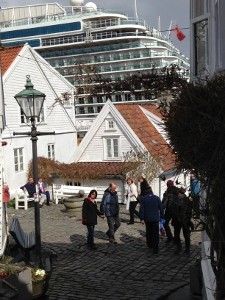 Old Stavanger juxtaposed with a towering cruise ship in the harbor.